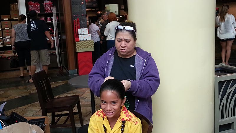 Andrea fixing Mālie Lyman's hair at the 2013 Ke Kula Mele Winter Concert
